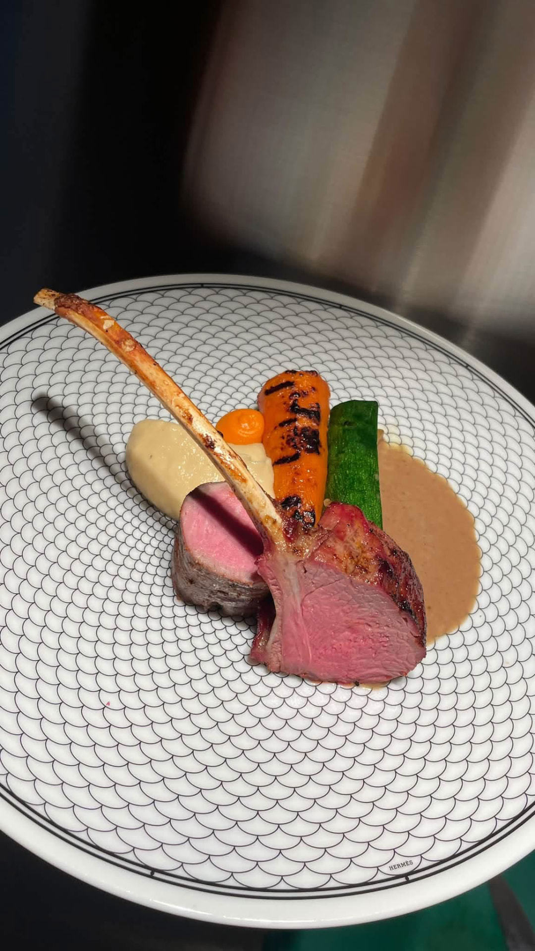 Herb-crusted lamb with charred carrot, courgette, and sauce